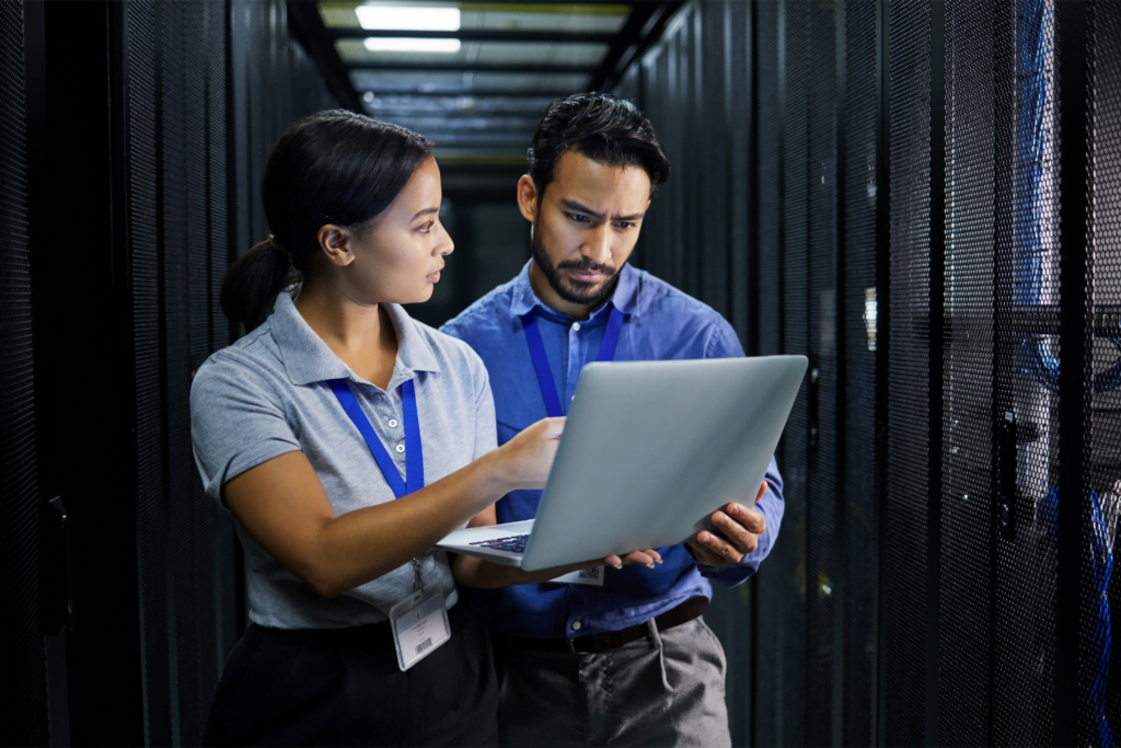 a man and woman looking at a laptop