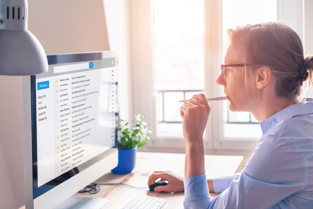 a woman sitting at a desk looking at a computer screen