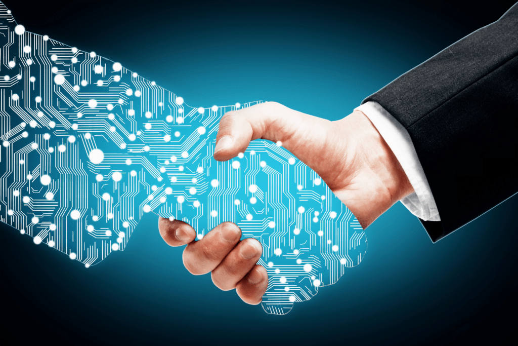 A human hand in a business suit shaking hands with a digital hand made of circuit board patterns against a blue illuminated background, symbolizing the partnership between technology and managed IT providers for law firms.