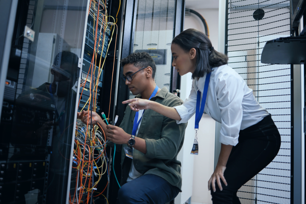 a man and a women technicians working on a network rack