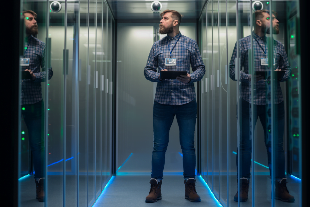 a man looking at servers in a data center