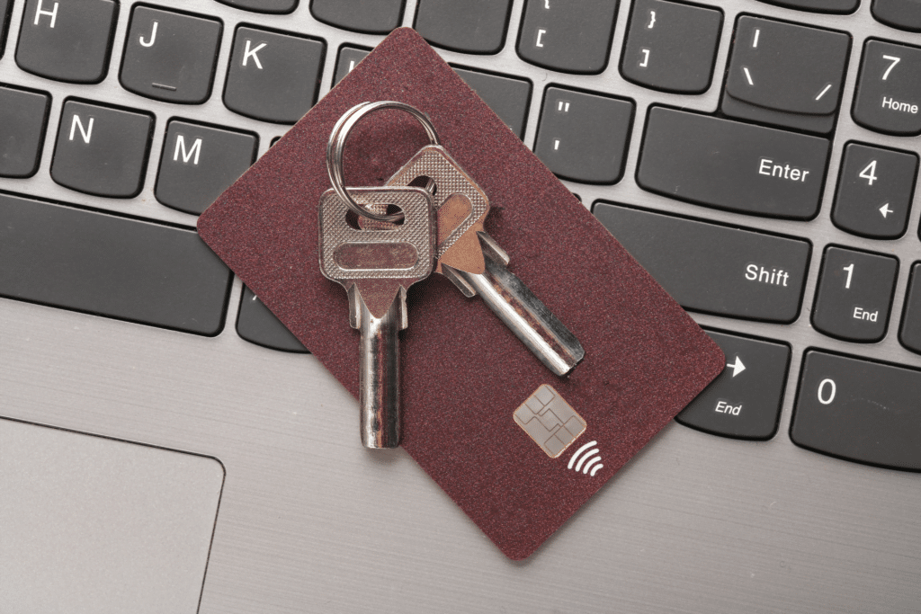 A set of keys and a credit card with a contactless payment symbol rest on a laptop keyboard, much like choosing between MSP vs MSSP for optimal digital security solutions.